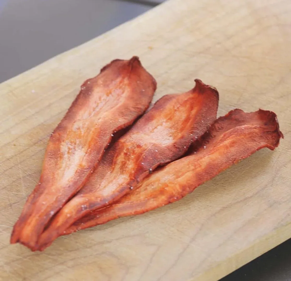 Three strips strongly resembling bacon in colour and shape, but tapered at one end, like sliced parsnip.