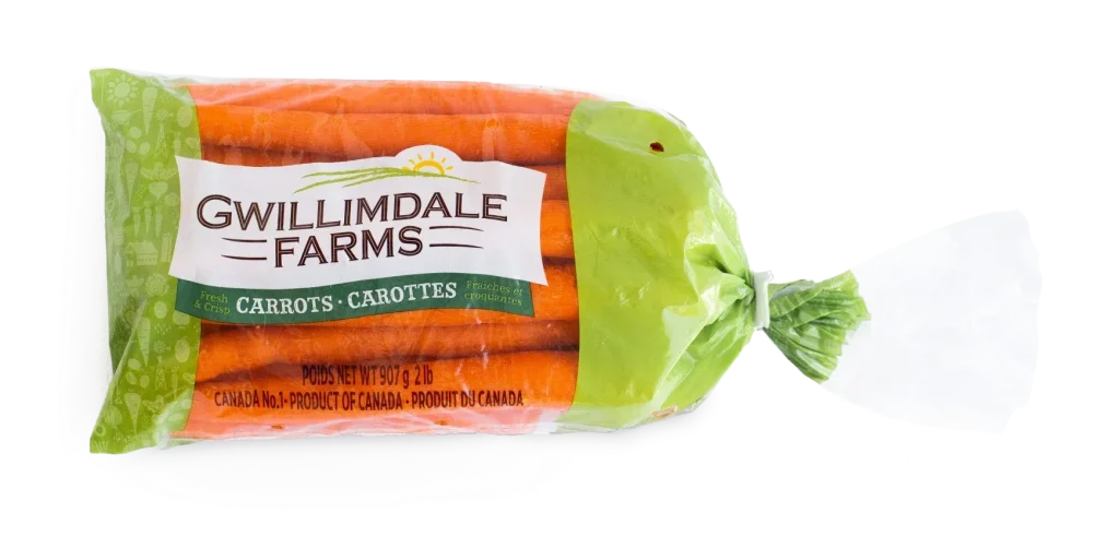A 2lb bag of Gwillimdale farms carrots. The top and bottom of the bag are solid light green, with a repeating pattern of various root vegetables, and farm imagery (barns, tractors, etc.). The middle 75% of the bag is transparent, showing the carrots inside, with a large white Gwillimdale Farms logo across part of the otherwise clear portion.